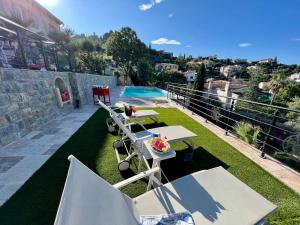 um pátio com mesas e cadeiras e uma piscina em Holiday home "225 Marc Chagall" em Mandelieu-la-Napoule