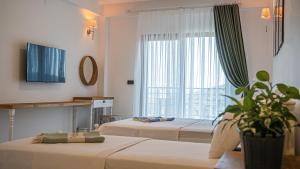 ein Hotelzimmer mit 2 Betten und einem Fenster in der Unterkunft Maslin Butik Otel in Gokceada Town