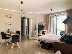 1 dormitorio con cama, mesa y comedor en Jezerní apartmán s terasou a saunou v Lakepark Residence en Doksy