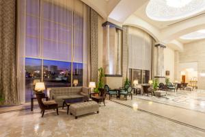 a lobby with a couch and chairs and windows at Melas Lara Hotel in Lara