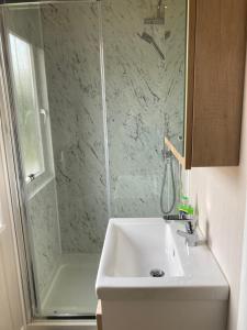 a bathroom with a sink and a shower at Chapel Fields Holiday Park in Chapel Saint Leonards