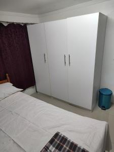 a bedroom with two white cabinets and a bed at Town Centre Stays in Nadi
