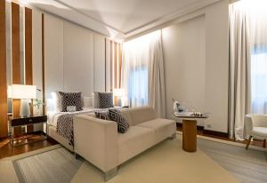 a living room with a couch and a bed at Hospes Amérigo, Alicante, a Member of Design Hotels in Alicante