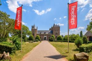una casa con dos banderas rojas delante de ella en Stayokay Hostel Heemskerk, en Heemskerk
