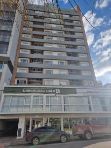 a tall building with cars parked in front of it at Neuquen Centro Departamento in Neuquén
