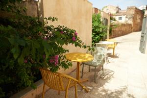 um grupo de cadeiras e uma mesa no passeio em Hotel Casa Palacio Pereros em Cáceres