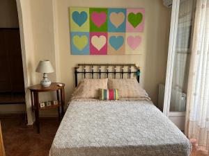 a bedroom with a bed with hearts on the wall at HABITACIÓN DOBLE o TRIPLE CORAZON DE RUZAFA in Valencia
