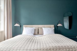 a blue bedroom with a large white bed with two lamps at Stylish 4 Bedroom flat in CPH City in Copenhagen