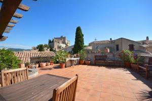 a patio with tables and benches on top of a building at Terrasses du château in Le Barroux