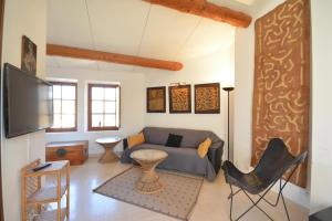 a living room with a couch and a tv at Terrasses du château in Le Barroux