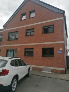 a white car parked in front of a brick building at Moderne Wohnung in Krefeld in Krefeld