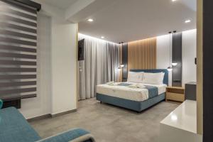 a bedroom with a bed and a couch in it at Nooa Villas in Skala Rachoniou