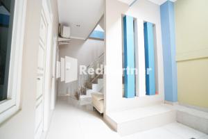 a hallway with blue and white walls and stairs at Indah Residence Syariah Mitra RedDoorz in Jakarta