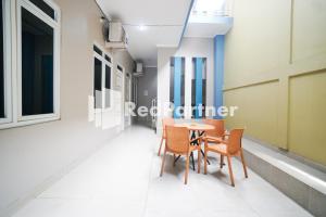 a corridor with a table and chairs in a building at Indah Residence Syariah Mitra RedDoorz in Jakarta
