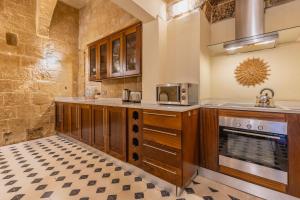 a kitchen with wooden cabinets and a stove at Stunning Valletta Palazzino in Valletta