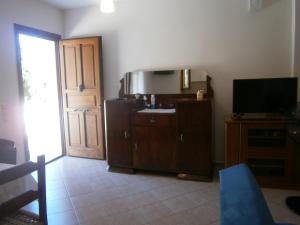 a living room with a door and a television at Moraki Apartment in Episkopión
