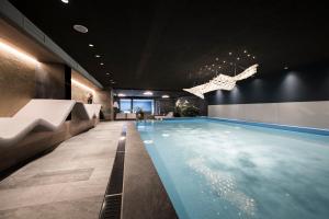 a swimming pool in a building with a ceiling at Post Hotel - Tradition & Lifestyle Adults Only in San Candido