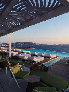 a resort with a pool and chairs and a swimming pool at Kouros Hotel & Suites in Mýkonos City