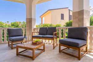 un patio con 3 sillas y una mesa de centro en Villa delle Lantane San Lorenzo Marzamemi, en Reitani