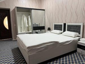 1 dormitorio con 1 cama grande y espejo grande en Orom Hotel Fergana, en Ferganá