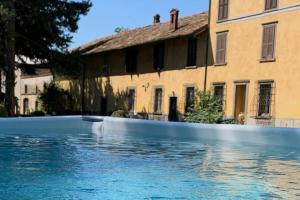 una piscina di fronte a un edificio di Cadepaoli Vineyard & Roses - Bergamo Countryside a Palosco