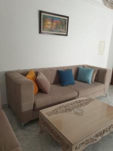 a living room with a brown couch and a coffee table at Appartement s+2 au plein coeur de sousse in Sousse
