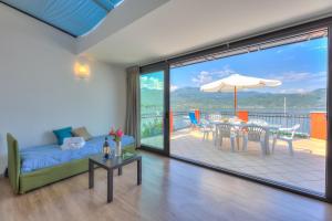 sala de estar con sofá y mesa en Red House Terrace Private Beach - Happy Rentals, en Baveno