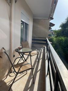 a table and chairs on the balcony of a house at Apartment by the Beach in Neoi Epivates