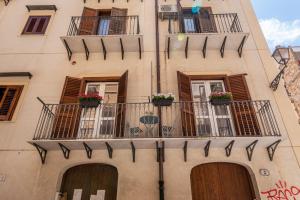 a building with balconies and flower boxes on it at Le Porte del Kassaro - Palermo Centro Storico Design Apartments & Balcony in Palermo