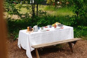 een tafel met een witte tafeldoek en voedsel erop bij De Buitenplek van Stek in Nunspeet