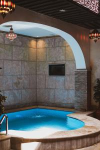 a swimming pool in a room with an archway at Riad Zyna in Meknès