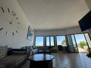 a living room with a couch and a clock on the wall at Appart-Hotel cabo negro in Cabo Negro