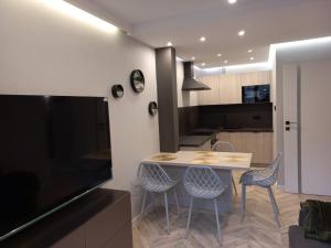 a kitchen and dining room with a table and chairs at Apartament Centrum - Szum potoku in Karpacz