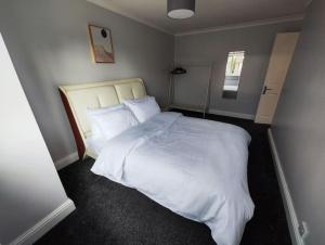 een slaapkamer met een bed met witte lakens en kussens bij Tranquil Retreat in Bicester in Bucknell