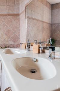 y baño con lavabo blanco y espejo. en Au jardin des gallinettes location villa piscine privée Carcassonne, en Alairac