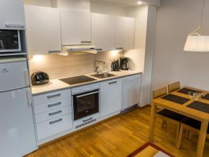 uma cozinha com armários brancos e uma mesa de madeira em Holiday Home Ruka ski chalets 46- 1207 by Interhome em Ruka