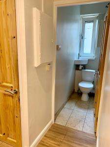 a bathroom with a toilet and a window at Victoria Park House R1 in London