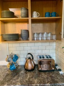 a kitchen counter with a toaster and cups and dishes at Victoria Park House R1 in London