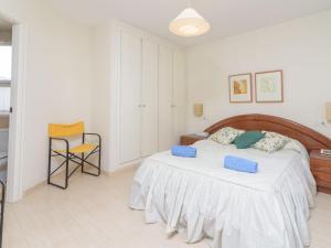 a bedroom with a bed with blue pillows on it at Apartment Villas del Mar by Interhome in Jávea