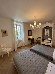 a bedroom with two beds and a chandelier at Les 3 Platanes in Conilhac-Corbières