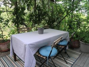 a table and chairs with a white table and trees at Apartment Branka by Interhome in Mošćenička Draga