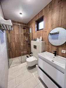 a bathroom with a shower and a toilet and a sink at Alma house - White in Almaty