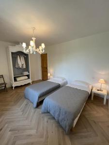 a bedroom with two beds and a chandelier at Les 3 Platanes in Conilhac-Corbières