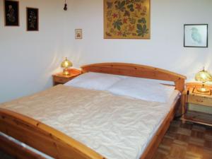 a bedroom with a wooden bed with two night stands at Apartment Kunzhof-4 by Interhome in Winklern