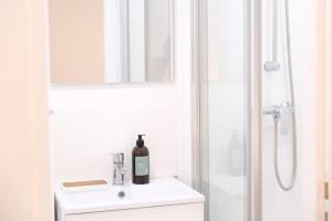 um banheiro com pia e chuveiro com espelho em Le Contemporain - Studio en hypercentre - Toulouse em Toulouse