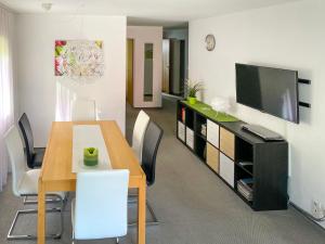 a dining room with a table and a tv at Apartment Utoring Acletta-1 by Interhome in Disentis