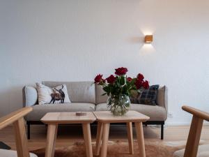 a living room with a couch and a vase of flowers on a table at Apartment Haut de Cry 16 by Interhome in Nendaz