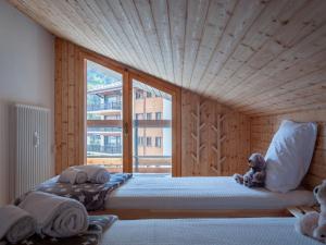 a bed in a room with a large window at Apartment Haut de Cry 16 by Interhome in Nendaz