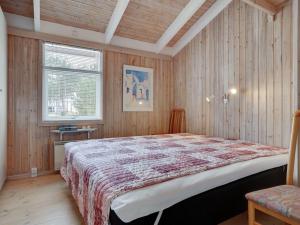 um quarto com uma cama grande num quarto com paredes de madeira em Holiday Home Alvy - 200m from the sea in Djursland and Mols by Interhome em Ebeltoft