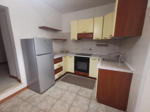 a kitchen with a stainless steel refrigerator and wooden cabinets at DOMVS GIVLIANO in Valguarnera Caropepe +4 photos